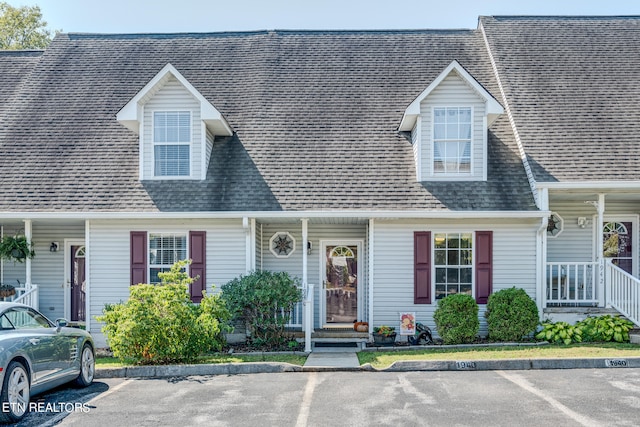 cape cod home featuring a porch