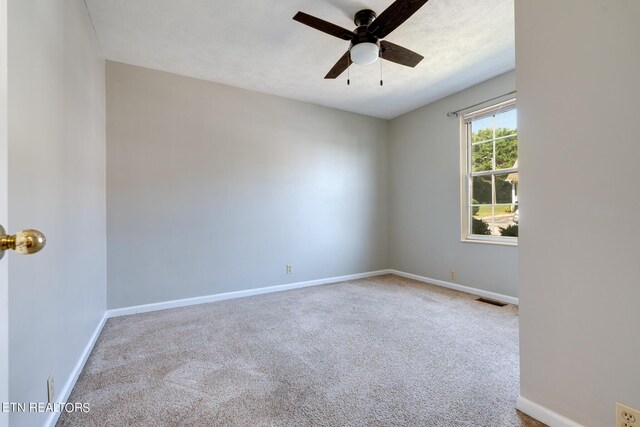 carpeted spare room featuring ceiling fan