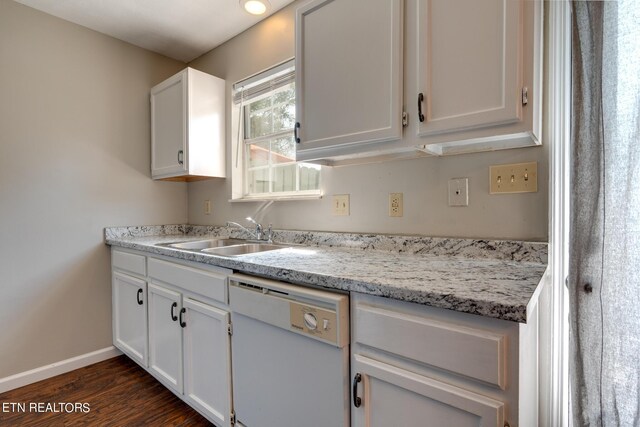 kitchen featuring white cabinets, dishwasher, light stone counters, dark hardwood / wood-style flooring, and sink