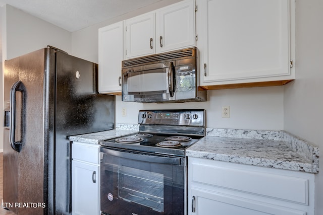 kitchen featuring a textured ceiling, black appliances, and white cabinets