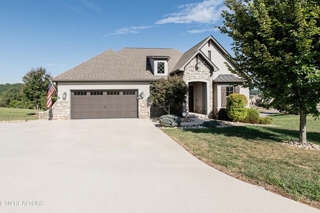 french country home with a garage and a front yard