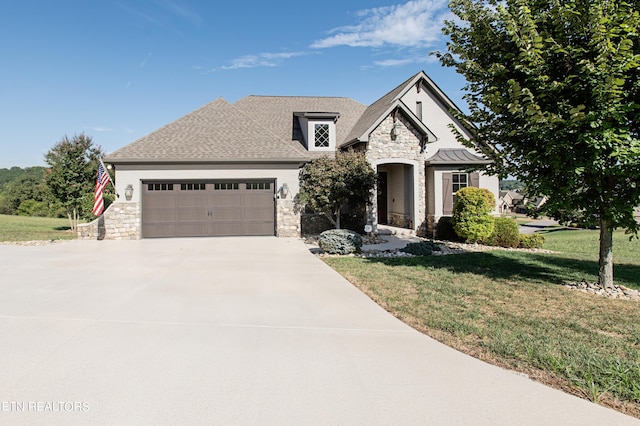 275 Hummingbird Dr, Vonore, TN 37885 - french country style house with a front yard, an attached garage, stucco siding, concrete driveway, and stone siding