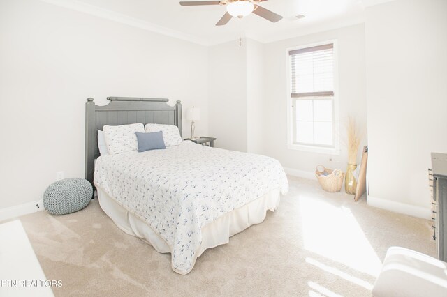 bedroom with crown molding, ceiling fan, and light carpet