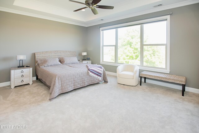 carpeted bedroom featuring a tray ceiling, ceiling fan, and crown molding