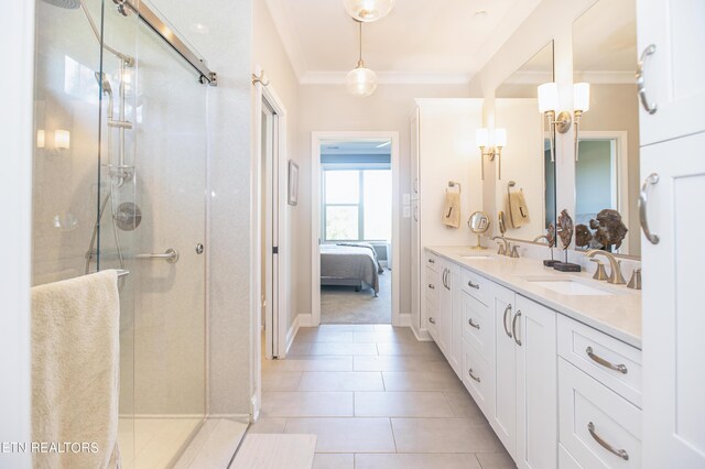 bathroom featuring a shower with door, vanity, tile patterned flooring, and crown molding