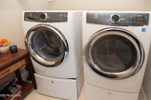 laundry area featuring independent washer and dryer and light tile patterned floors