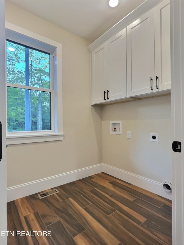 laundry room featuring dark wood-type flooring, hookup for a washing machine, cabinets, and electric dryer hookup