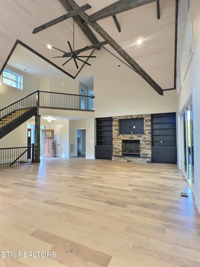 unfurnished living room featuring a fireplace, high vaulted ceiling, ceiling fan, and light hardwood / wood-style floors