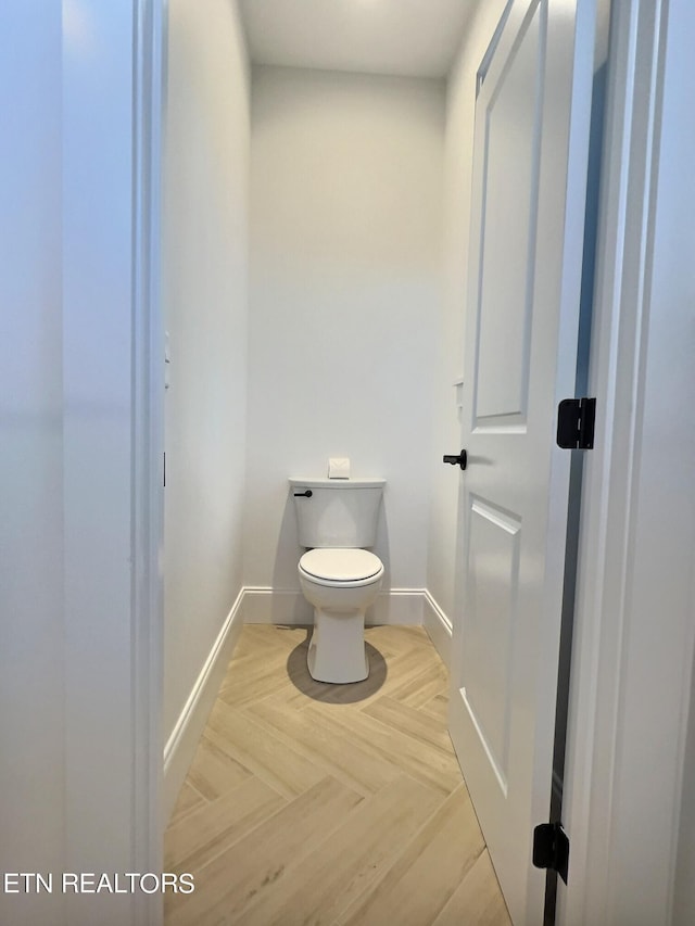bathroom with baseboards and toilet