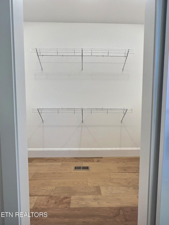 walk in closet with light wood-type flooring