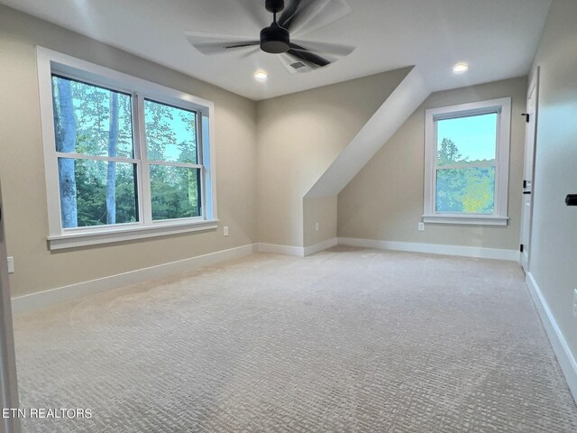 bonus room with ceiling fan and carpet floors