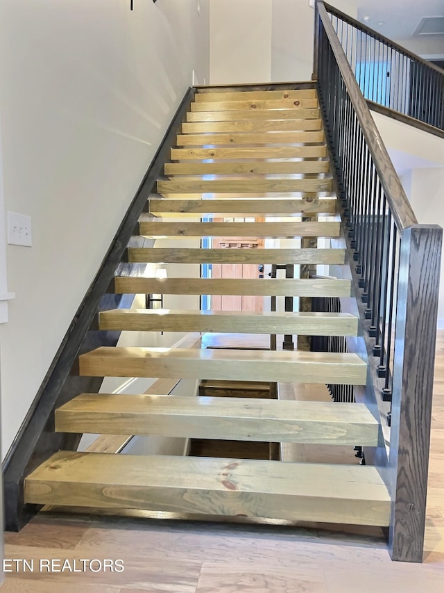 stairway with hardwood / wood-style flooring