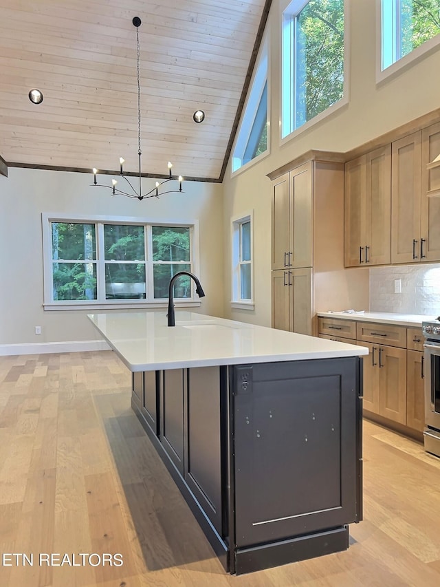 kitchen featuring light countertops, tasteful backsplash, a sink, an inviting chandelier, and wood ceiling