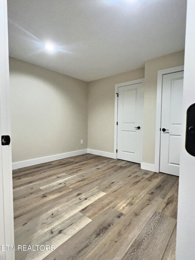 unfurnished room featuring baseboards and wood finished floors