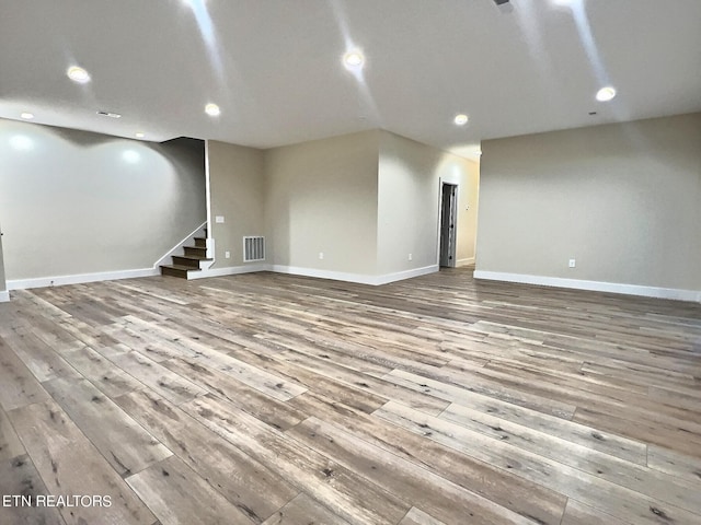 below grade area with stairs, wood finished floors, baseboards, visible vents, and recessed lighting