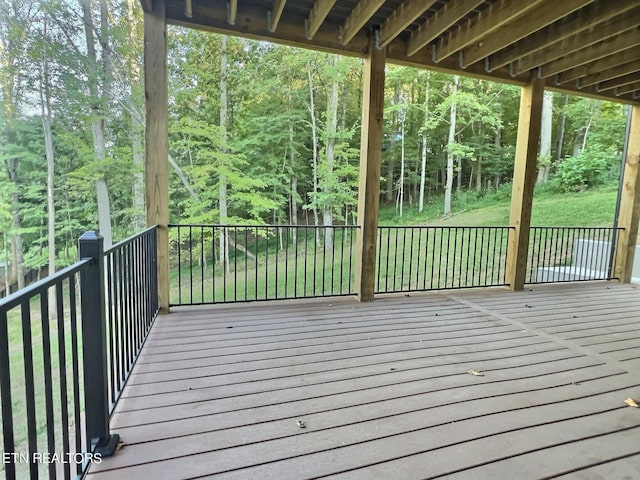 wooden terrace featuring a forest view