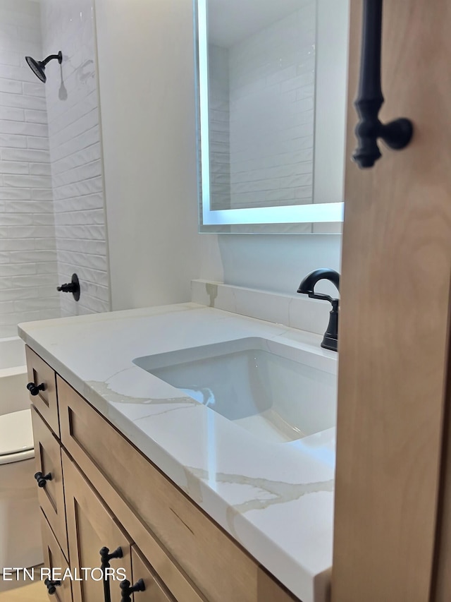 bathroom with toilet, vanity, and shower / tub combination