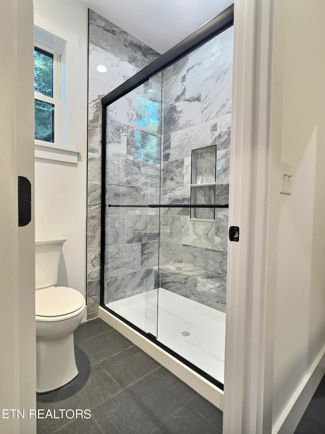 full bathroom with a shower stall, tile patterned floors, and toilet