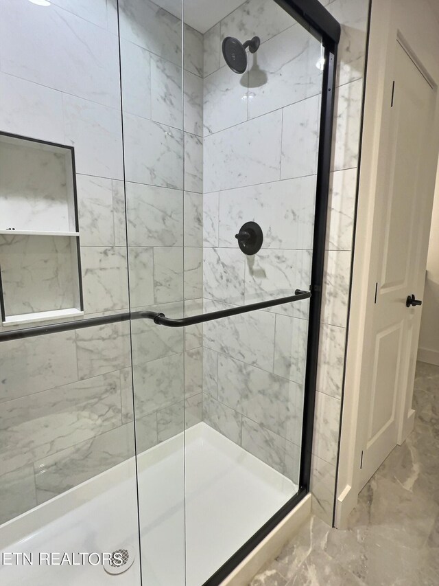 bathroom featuring a shower with shower door