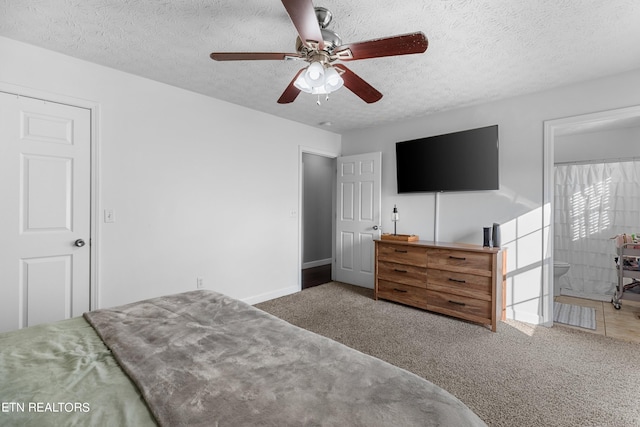 carpeted bedroom featuring ceiling fan, connected bathroom, and a textured ceiling