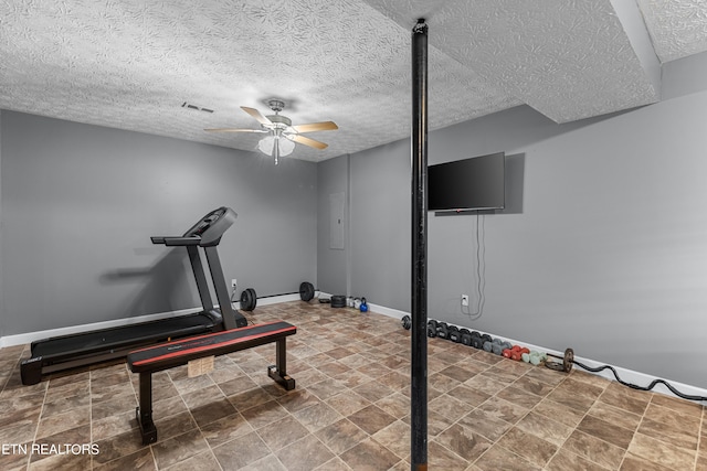 exercise area featuring a textured ceiling and ceiling fan