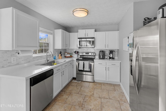 kitchen with white cabinets, appliances with stainless steel finishes, tasteful backsplash, and sink