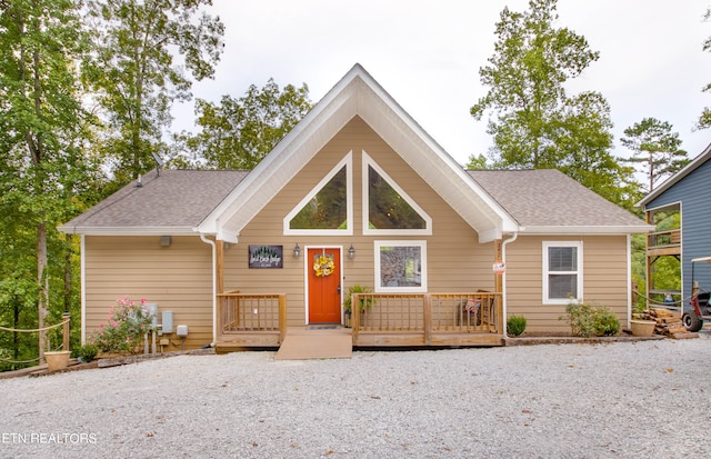 view of front of property featuring roof with shingles and a wooden deck