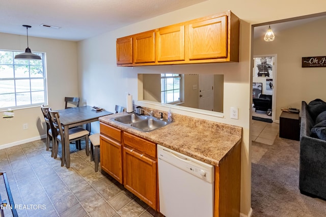 kitchen with visible vents, a sink, light countertops, pendant lighting, and dishwasher