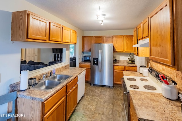 kitchen featuring under cabinet range hood, a sink, backsplash, stainless steel appliances, and light countertops