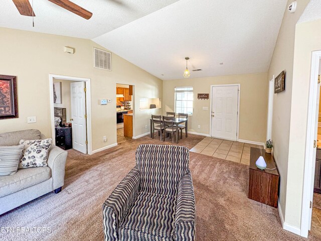 living area featuring visible vents, a ceiling fan, carpet floors, baseboards, and vaulted ceiling