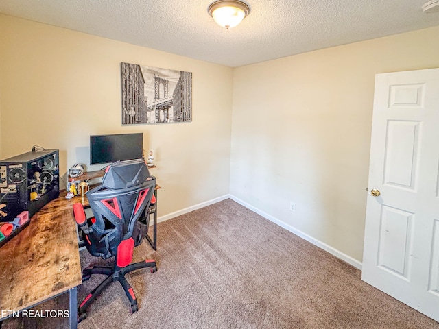 carpeted home office with a textured ceiling and baseboards