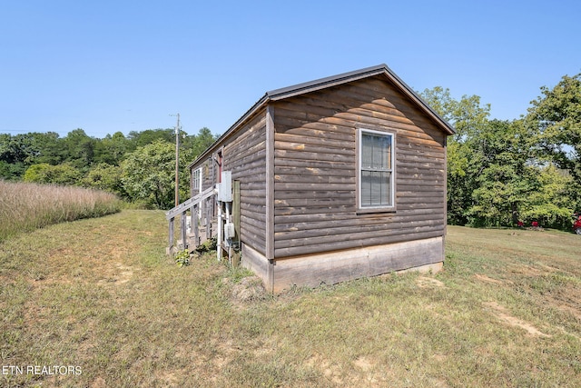 view of side of home featuring a yard and an outdoor structure