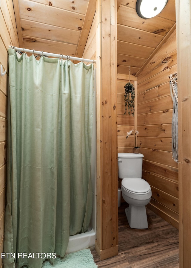 bathroom with lofted ceiling, toilet, hardwood / wood-style floors, and wood walls