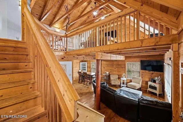 stairway with wood ceiling, wood walls, wood-type flooring, and vaulted ceiling with beams