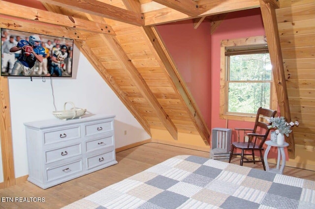 bedroom featuring light hardwood / wood-style flooring and lofted ceiling with beams