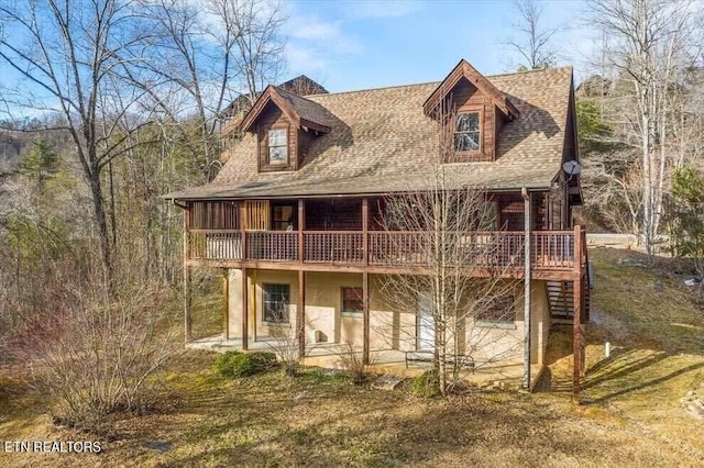 back of property featuring a lawn and a wooden deck