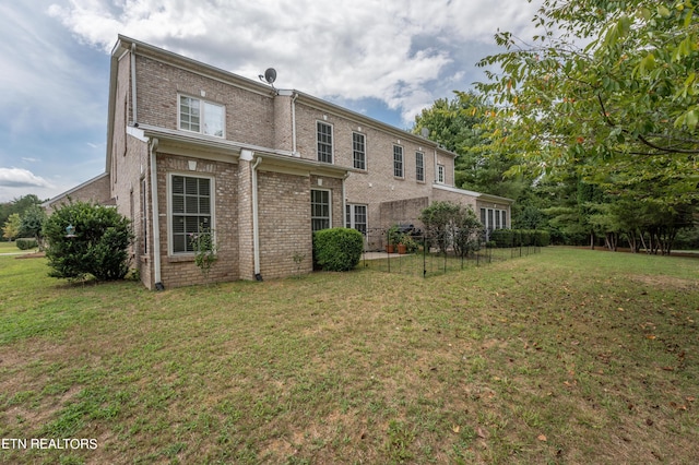 rear view of property featuring a yard