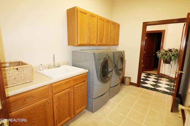 washroom featuring light tile patterned floors, cabinets, washer and dryer, and sink