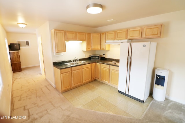 kitchen featuring white refrigerator with ice dispenser, light colored carpet, light brown cabinetry, and sink