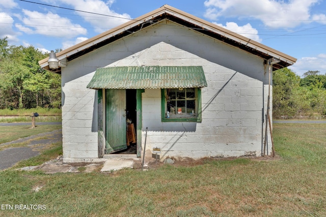 view of front facade with concrete block siding and a front yard