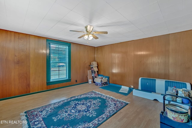 rec room with wood finished floors, a ceiling fan, and baseboards