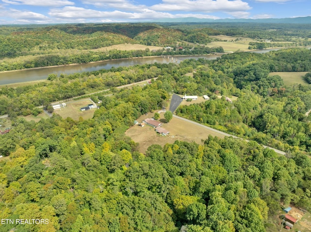 birds eye view of property featuring a water view and a wooded view