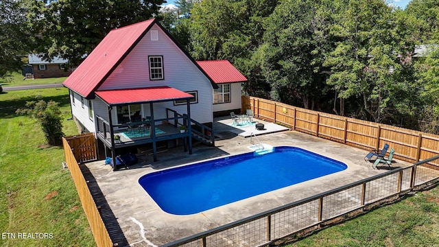 view of pool with a yard, a wooden deck, and a patio area