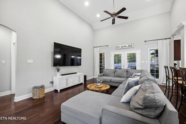 living area with high vaulted ceiling, ceiling fan, dark wood finished floors, arched walkways, and french doors