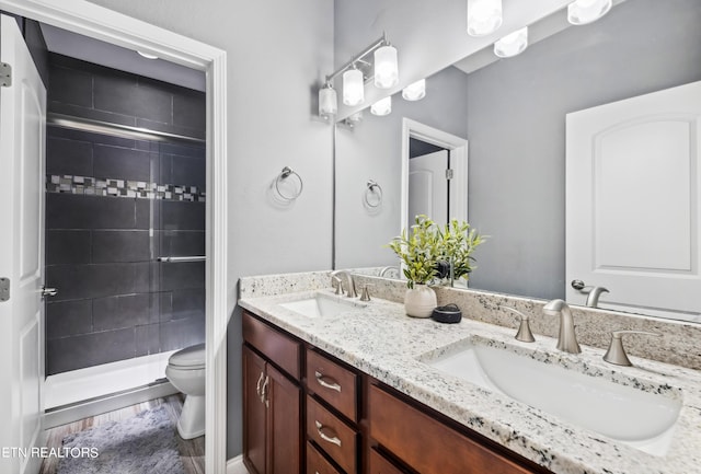 full bath featuring toilet, a sink, and a stall shower