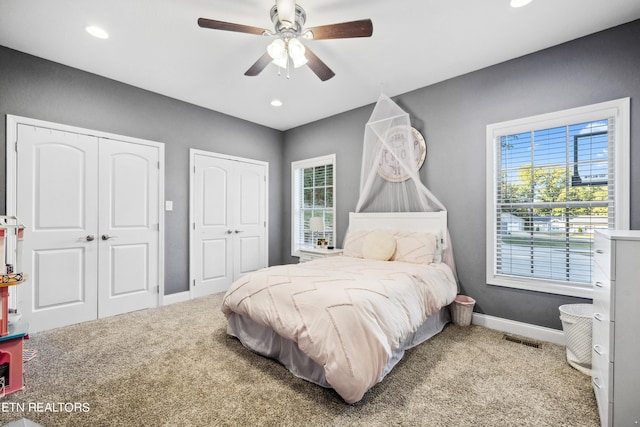 bedroom featuring two closets, baseboards, recessed lighting, a ceiling fan, and carpet floors