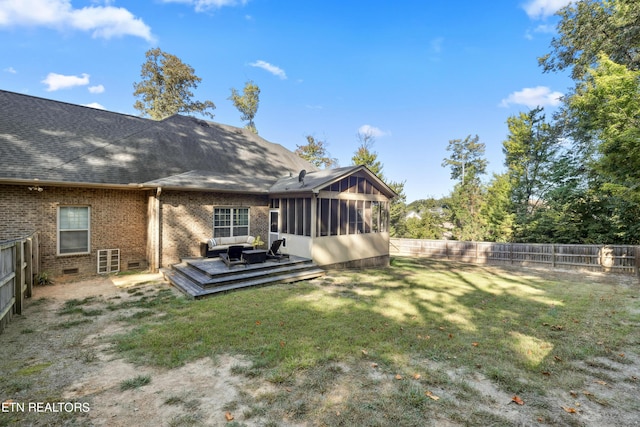 back of property with a deck, brick siding, a fenced backyard, a sunroom, and a lawn