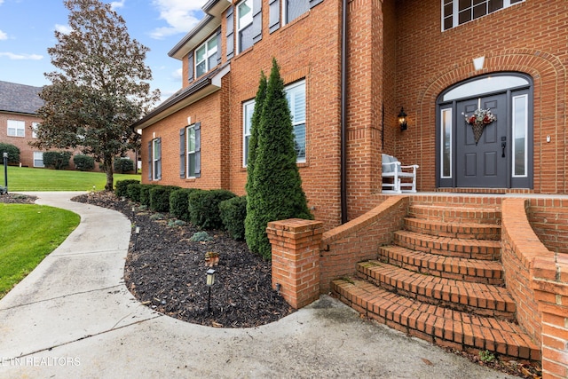 view of exterior entry featuring a yard