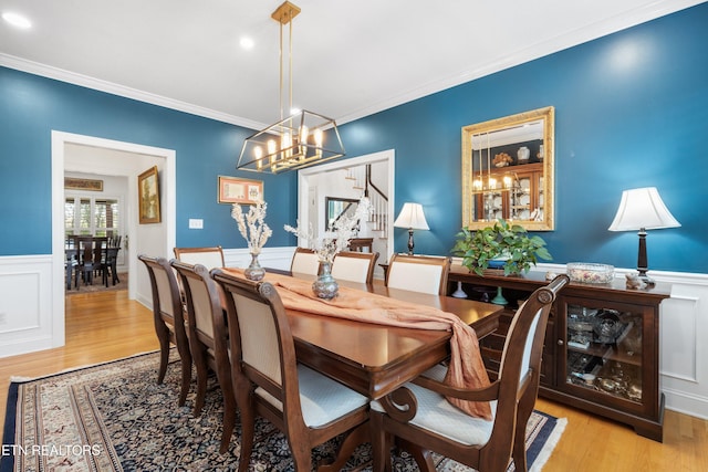 dining space featuring light hardwood / wood-style flooring and crown molding