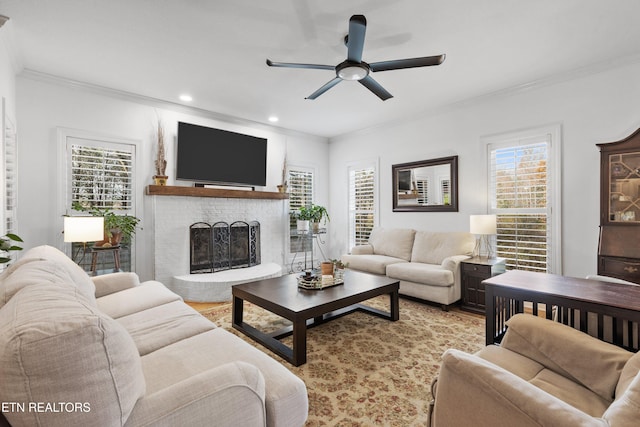 living room with ceiling fan, a healthy amount of sunlight, crown molding, and a brick fireplace